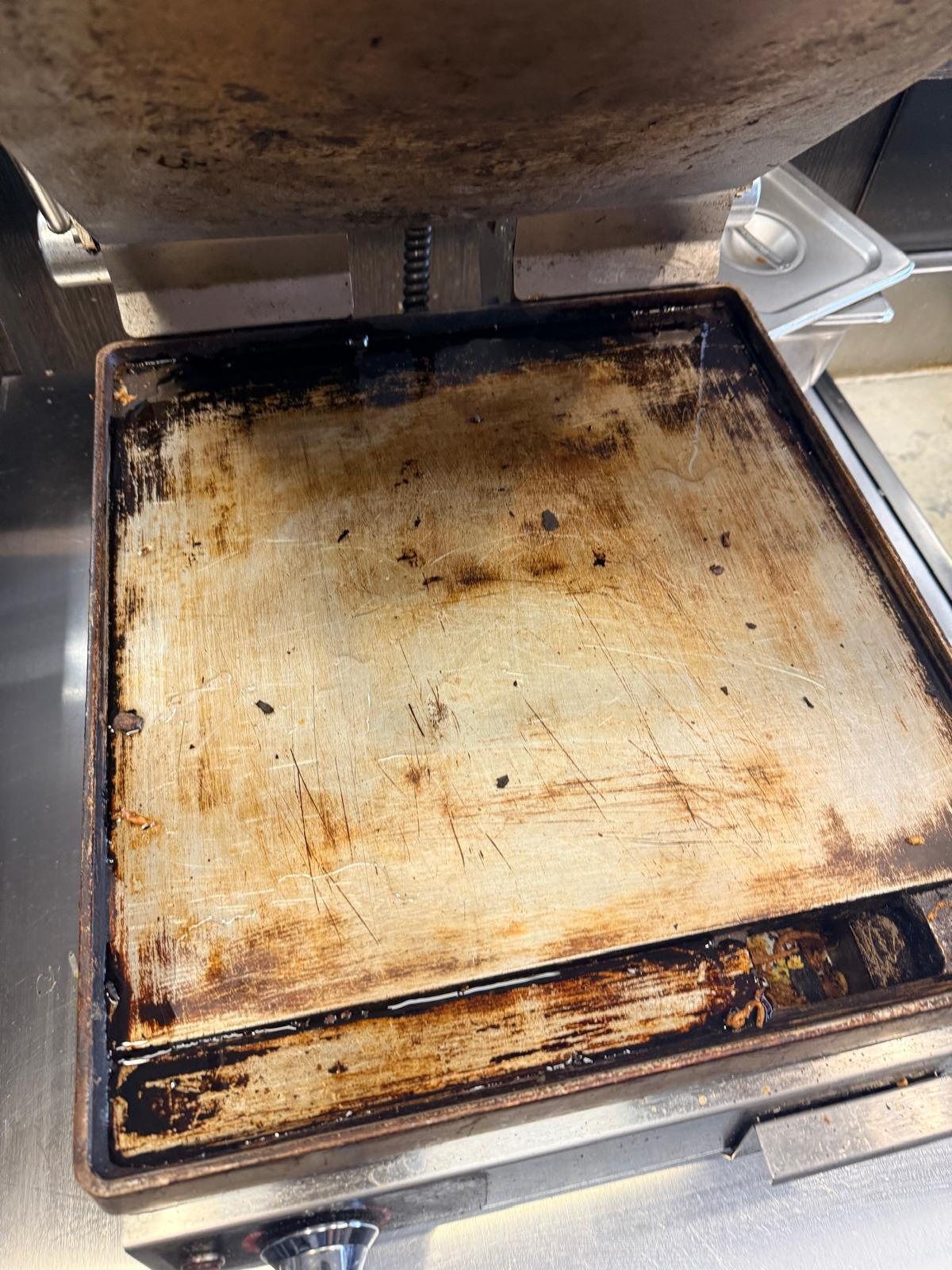 Soiled commercial griddle before VIVE-GRILL application